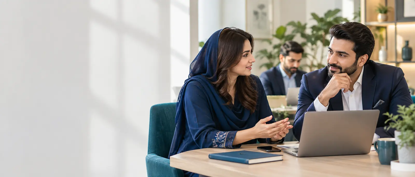 Business professionals discussing plans over a laptop in a modern office